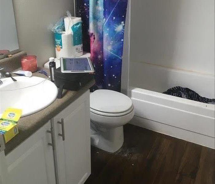 Residential bathroom with a white tub and toilet 