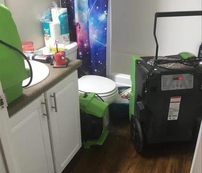 a residential bathroom with drying equipment in place 