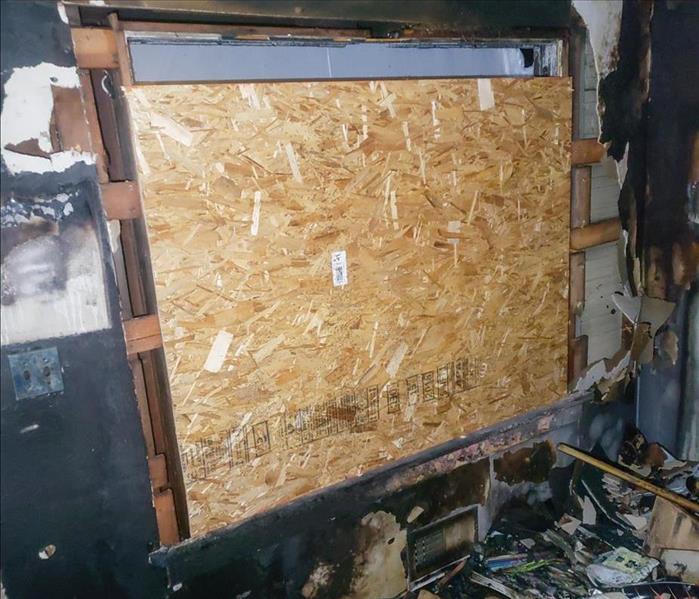 Smoke damage on the walls around a boarded up window in a Seattle home